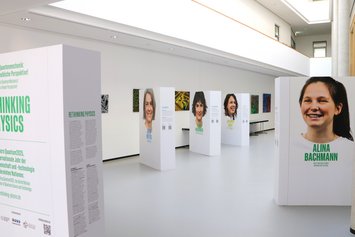 Mehrere Frauengesichter und deren Namen mit kleinen Texten sind auf großen Pappstelen im Atrium des IFW Dresden zu sehen.